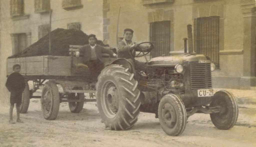 Uno de los primeros tractores con ruedas de goma que vino a Mota del Cuervo. Era de la marca «Case» y pertenecía a don Rafael Fernández González-Granda, heredero universal de doña Asunción Ortega Belinchón, más conocida como la Serrana. El conductor es Miguel Tinajero Moreno [†]; sentado en el asiento del remolque, cargado con basura, Román Tinajero Moreno, su hermano; y el chicote que está de pie es Faustino Tirado Martínez. La fotografía está hecha en la plaza del Toril (actualmente plaza de Cervantes) allá por el año 1955 aproximadamente